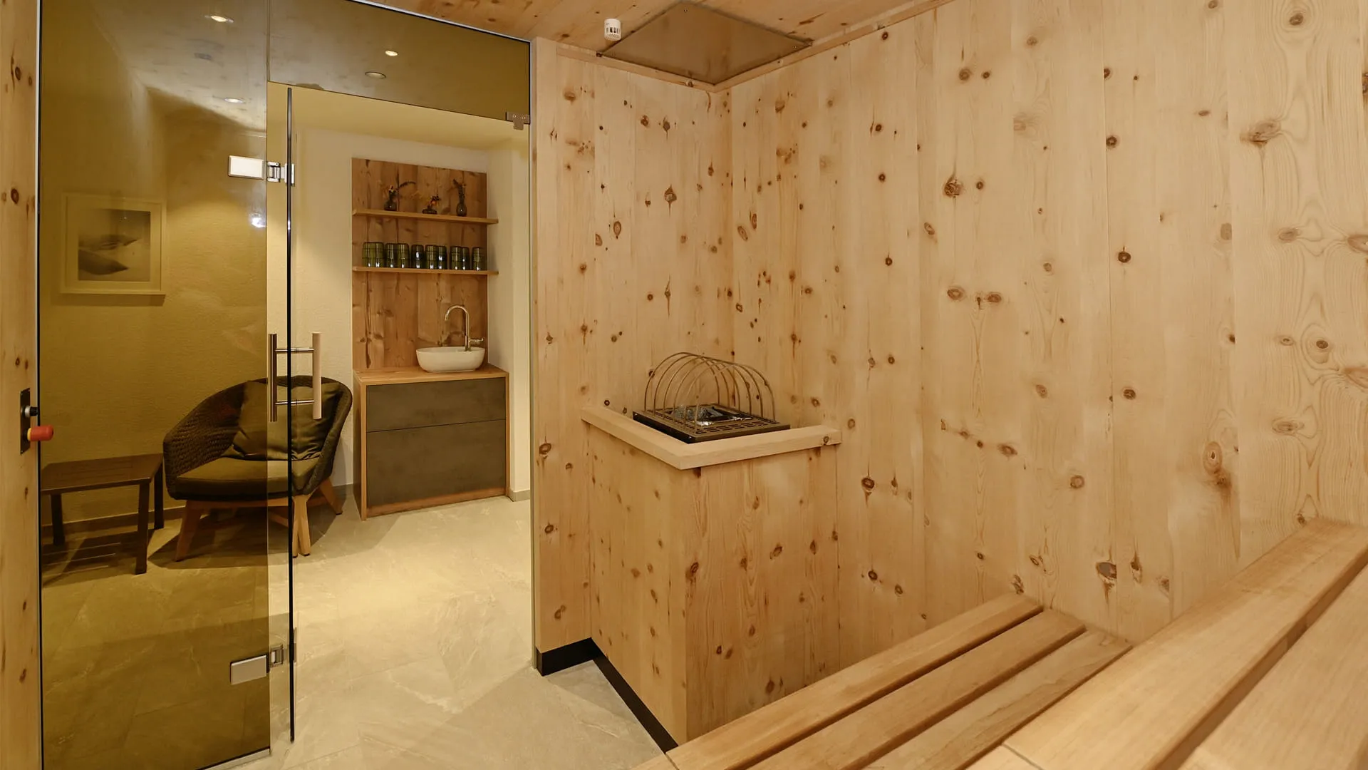 Innenansicht einer Sauna mit Holzverkleidung und Waschtisch