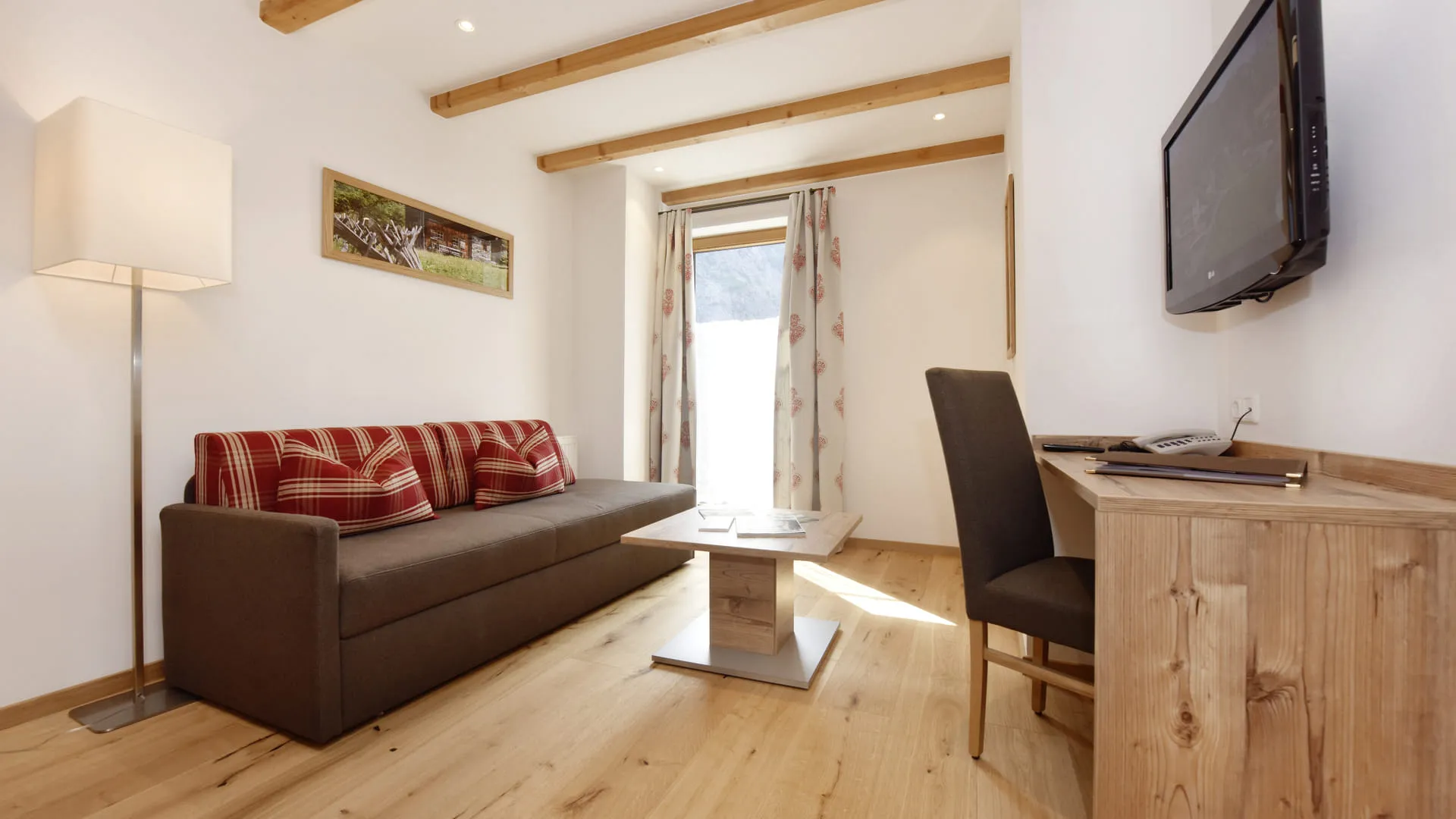 Modernes Wohnzimmer mit braunem Sofa, Holztisch und TV