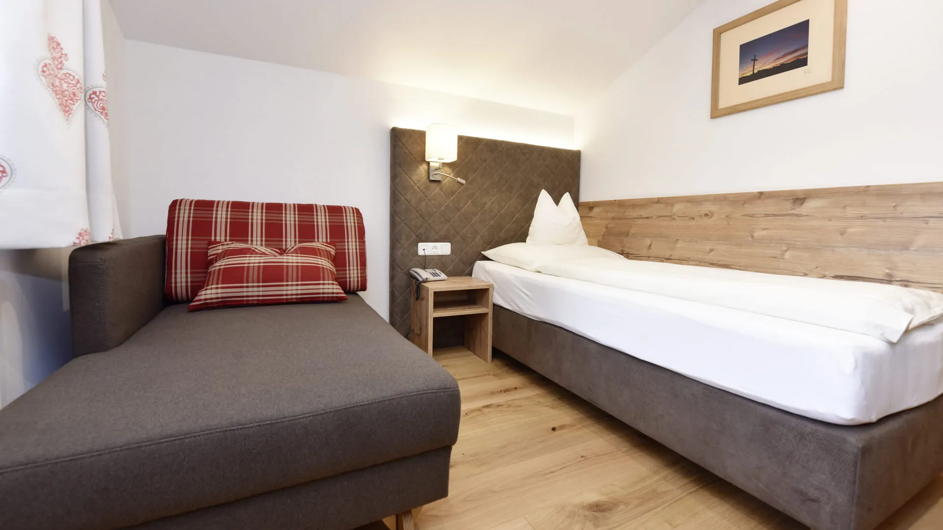 Gemütliches Zimmer mit einem Schlafsofa und einem Holzrahmenbett