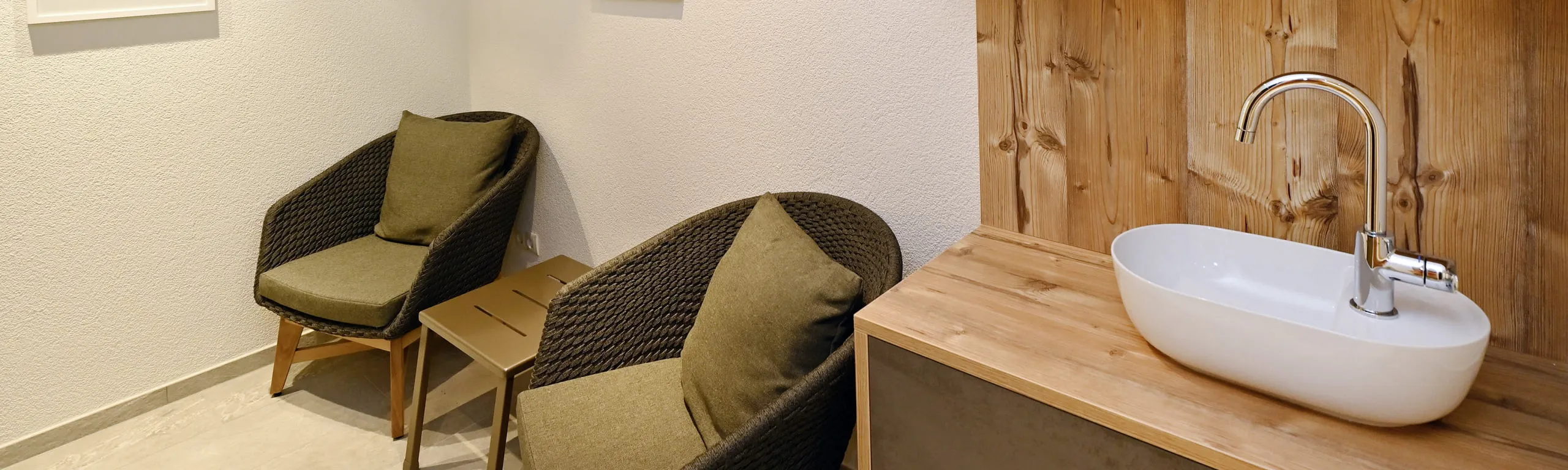Gemütliche Sitzecke mit zwei Stühlen und einem modernen Waschbecken auf einer Holzarbeitsplatte